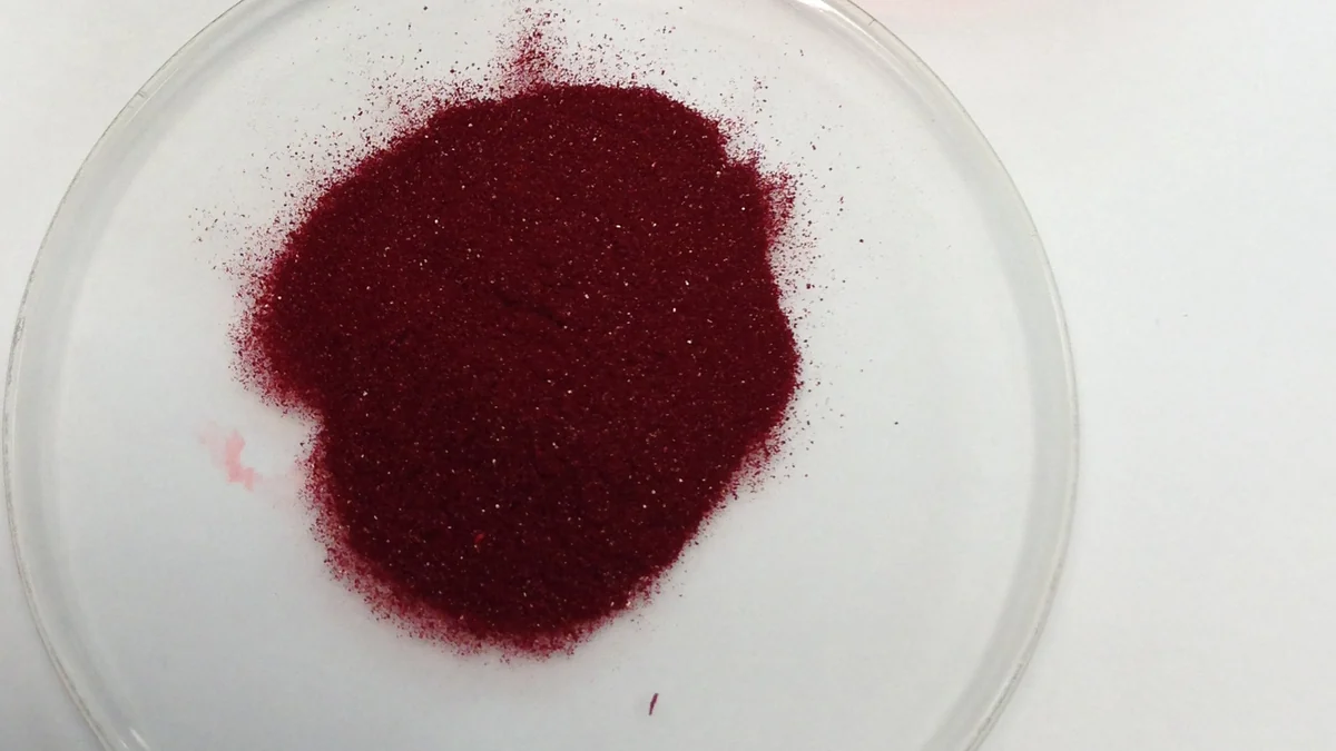 Dark red methylcobalamin vitamin B12 powder in a laboratory dish